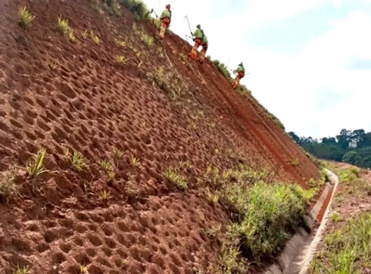 Homens trabalhando com aplicação de manta fibra de coco para aplicação de Hidrossemeadura em talude